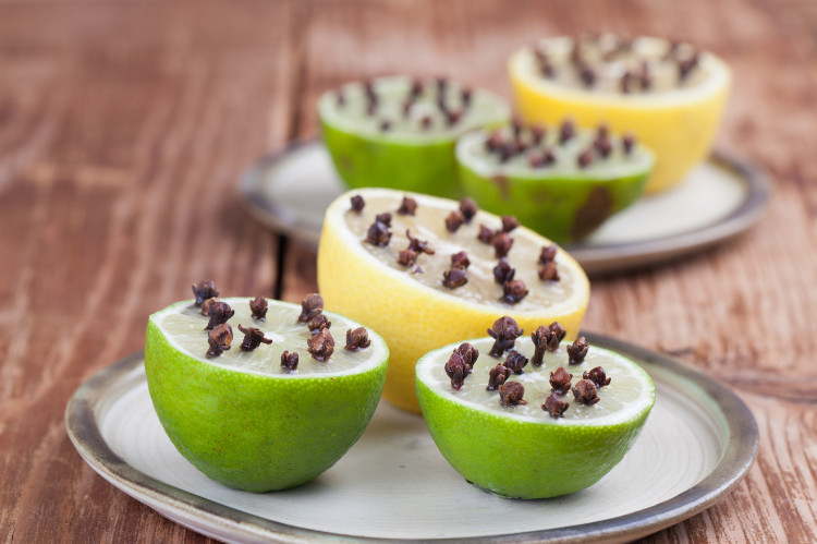 ikiye bölünmüş ve içlerine karanfil saplanmış limon ve misket limonu